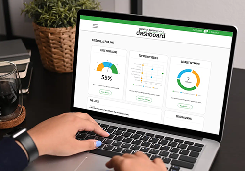 Person typing on a laptop displaying a dashboard with score tiles and charts, including a prominent 55% gauge.