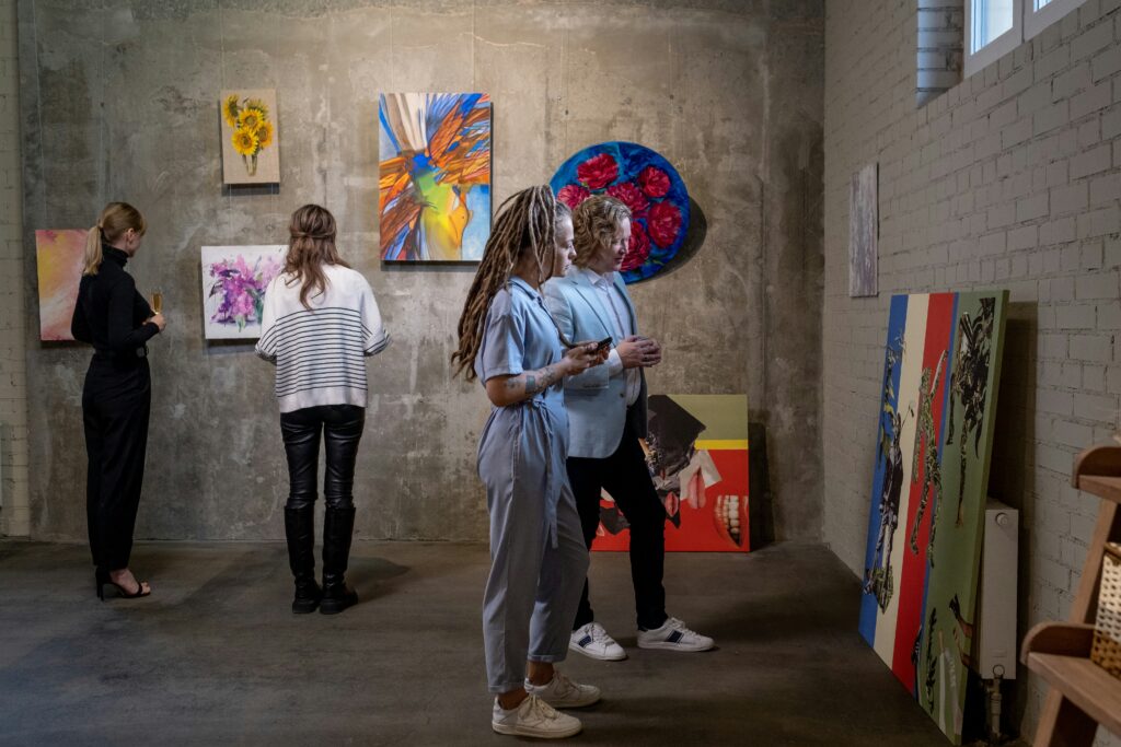 People looking at art on cement walls.